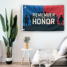 Load image into Gallery viewer, In a home setting, a flag with the saying &quot;Remember And Honor&quot; is mounted on a white wall by a side table.
