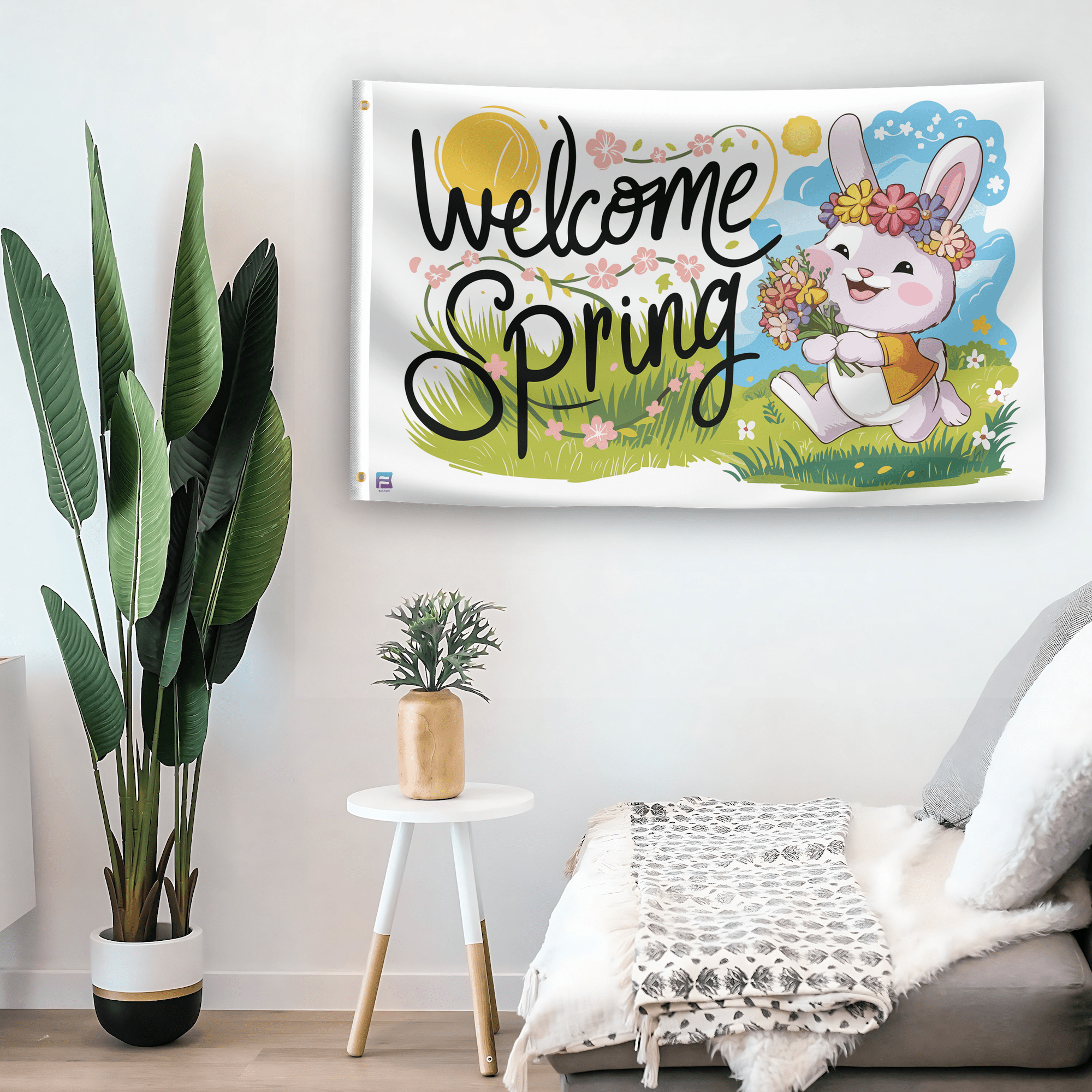 In a home setting, a flag with the saying "Welcome Spring" is mounted on a white wall by a side table.