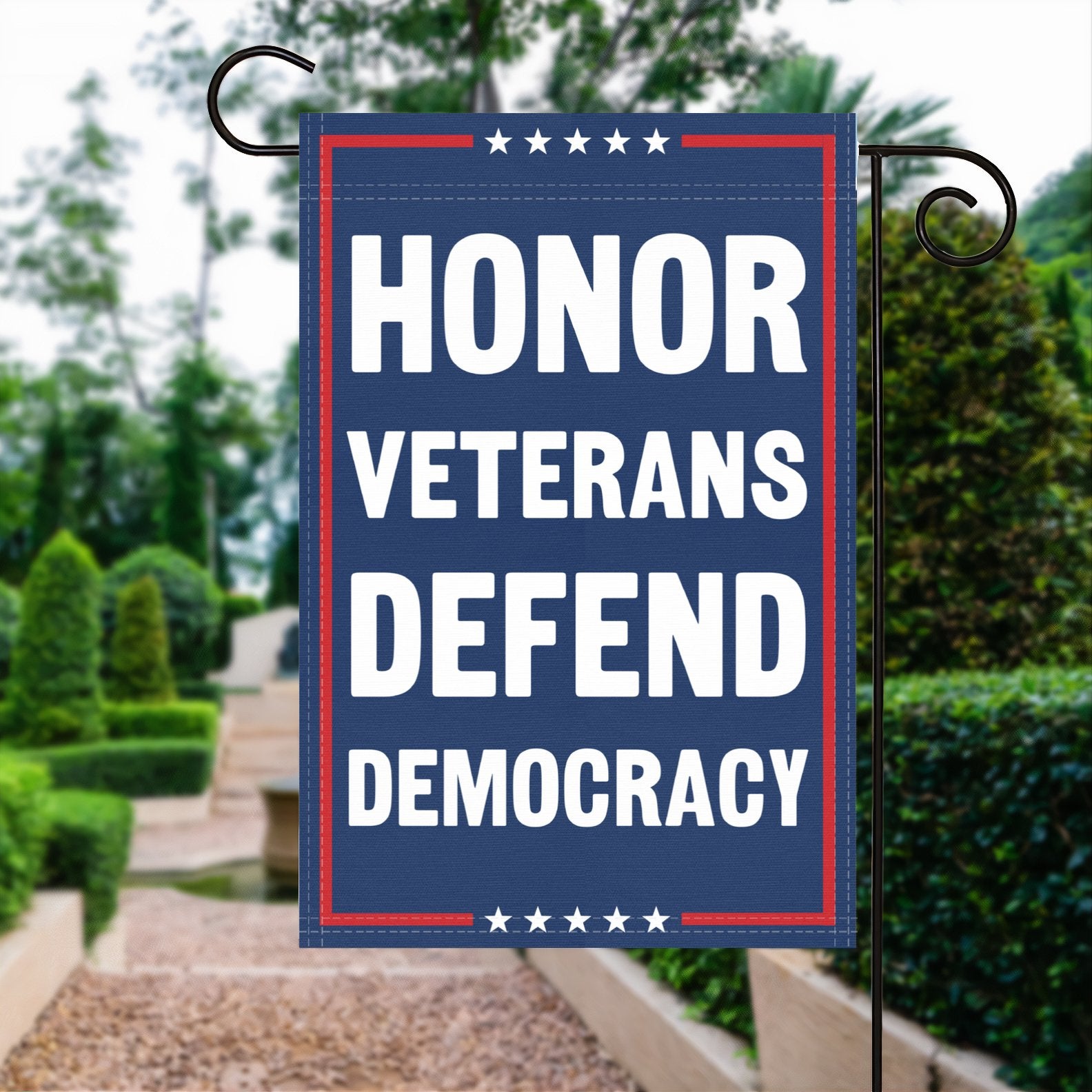 A red, white and blue political garden flag with the slogan Honor Veterans Defend Democracy.