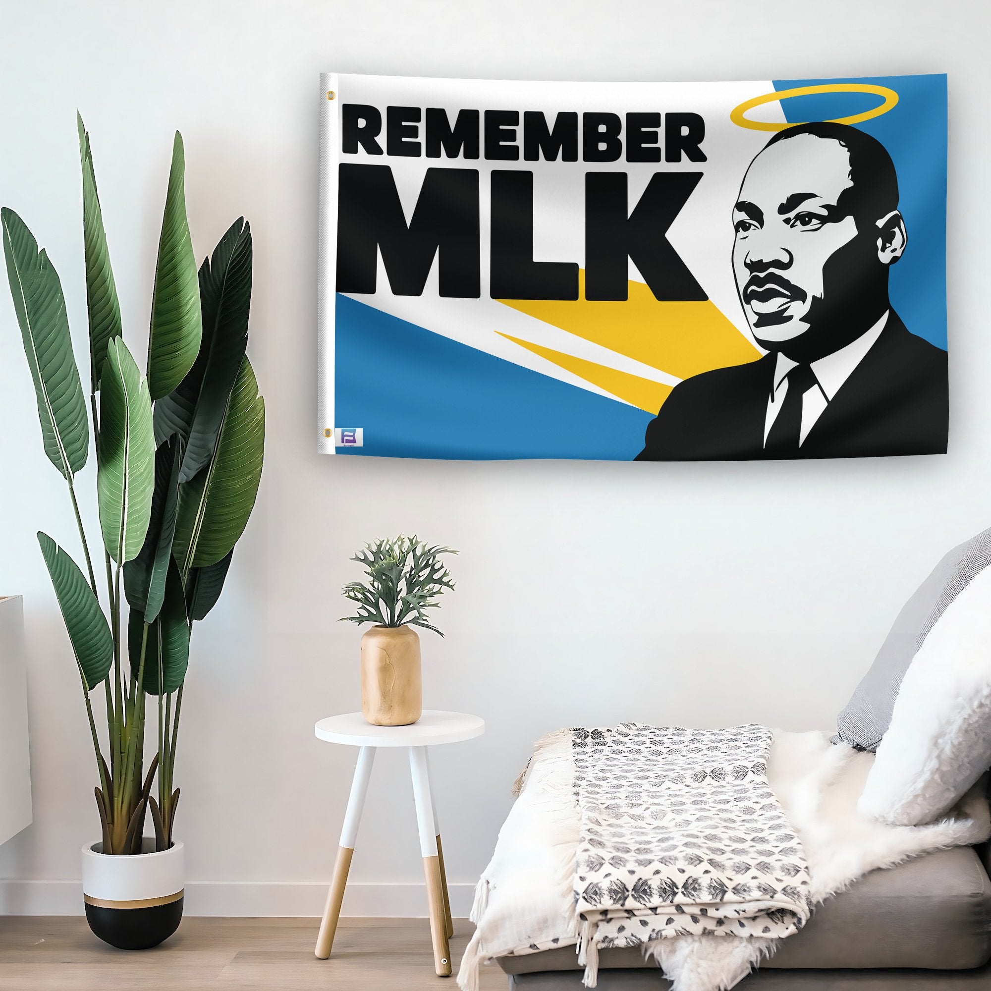 In a home setting, a flag with the saying "Remember MLK" is mounted on a white wall by a side table.