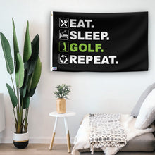 Load image into Gallery viewer, In a home setting, a flag with the saying &quot;Eat Sleep Golf Repeat&quot; is mounted on a white wall by a side table.
