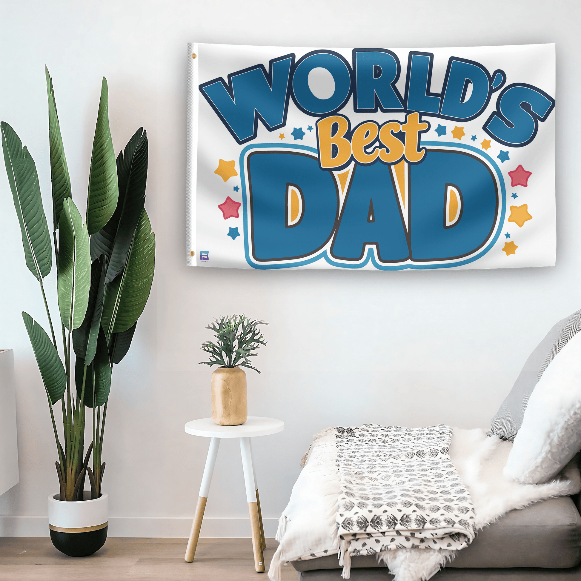 In a home setting, a flag with the saying "World's Best Dad" is mounted on a white wall by a side table.