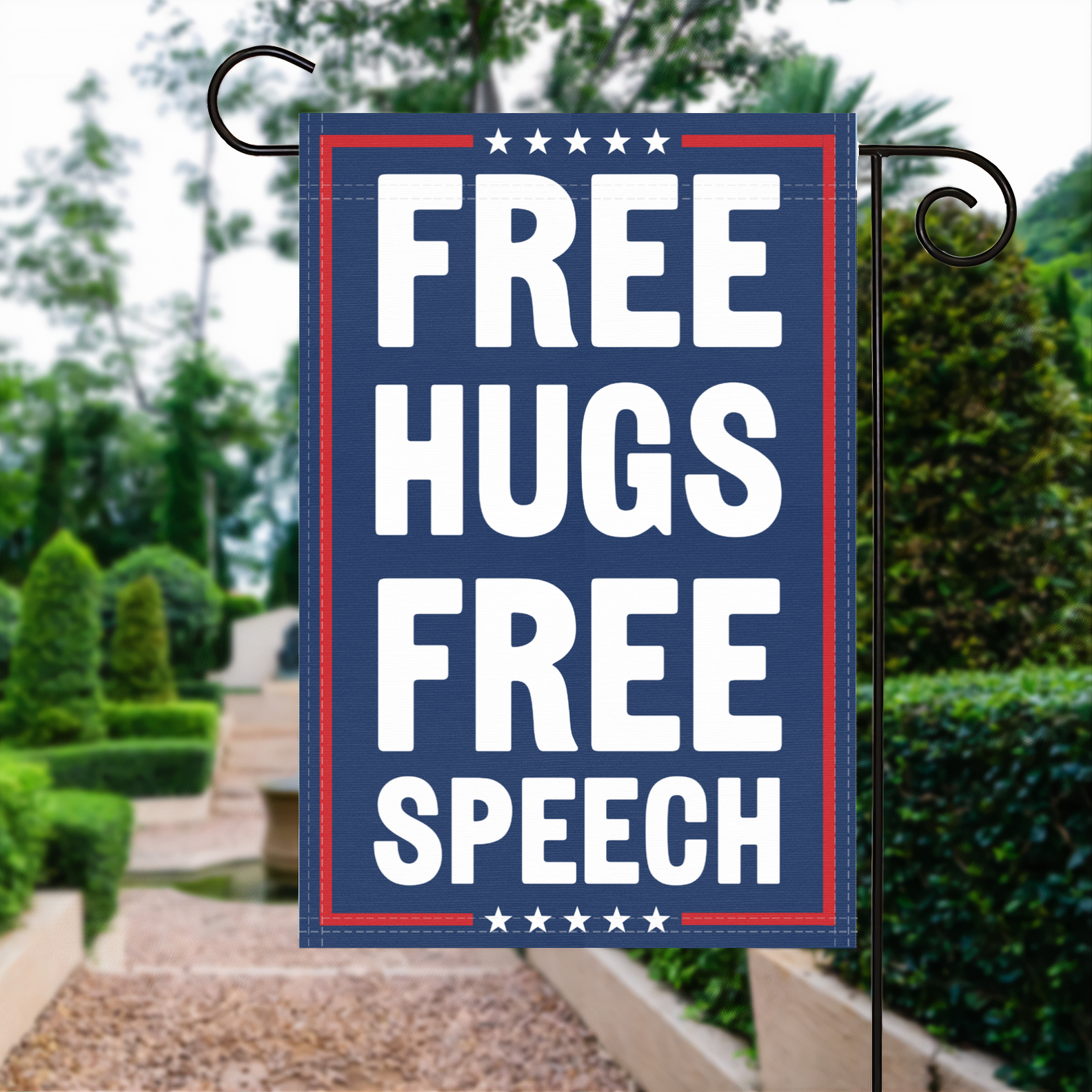 A red, white and blue political garden flag with the slogan Free Hugs Free Speech.