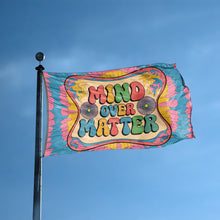 Load image into Gallery viewer, A flag with the saying &quot;Mind Over Matter&quot; displayed on a high pole, with a tie dye style color scheme.
