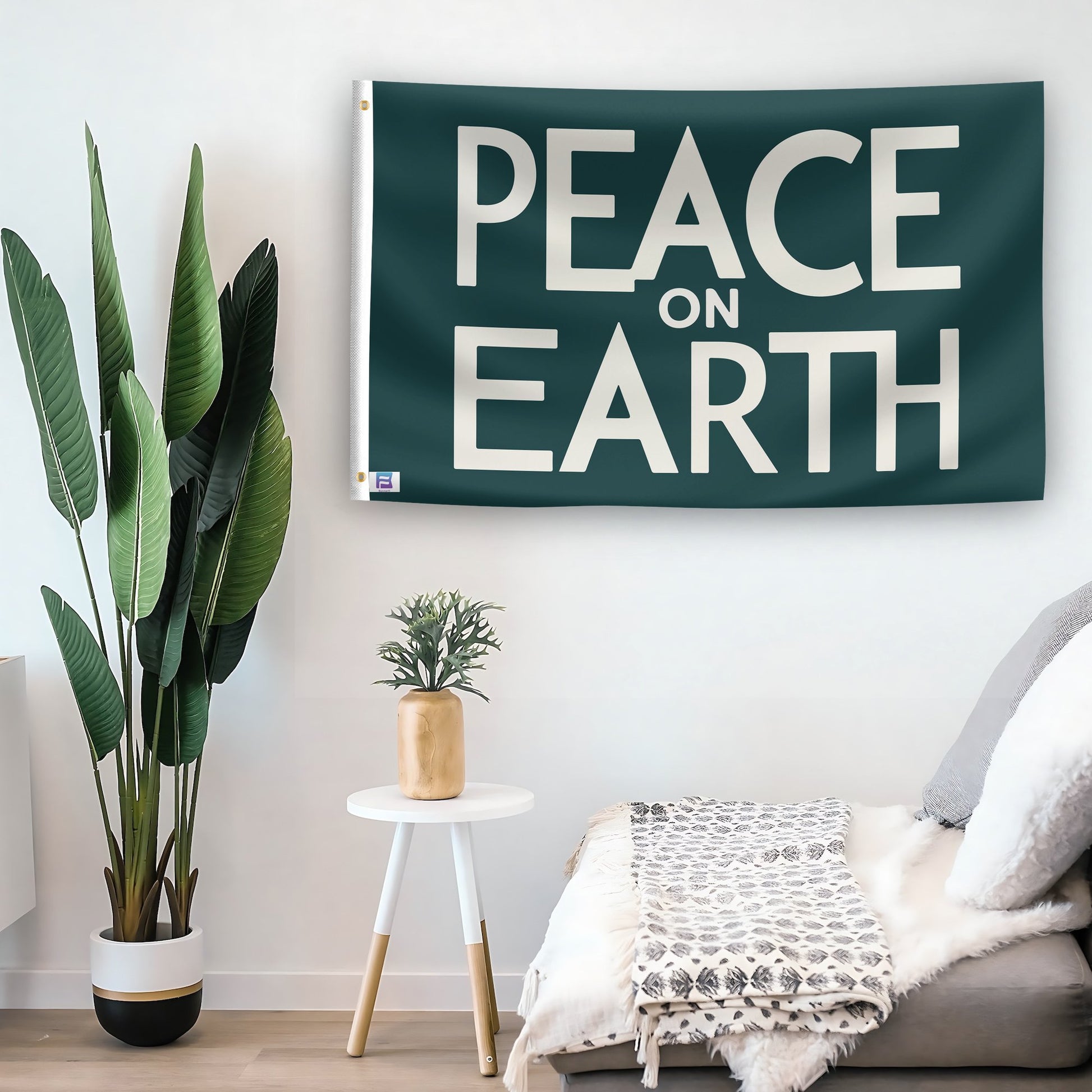 In a home setting, a flag with the saying "Peace On Earth" is mounted on a white wall by a side table.