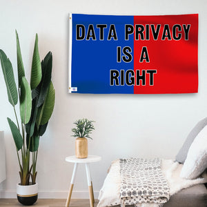 In a home setting, a blue and red flag with a political slogan is mounted on a white wall by a side table.