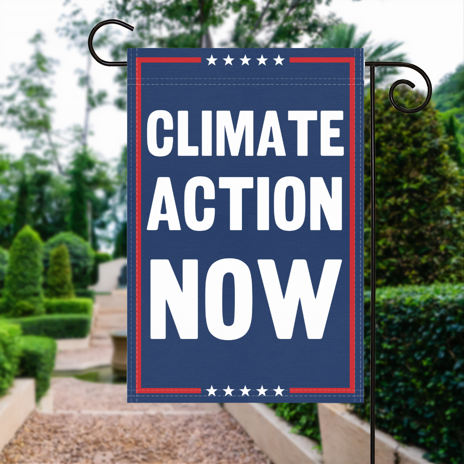 A red, white and blue political garden flag with the slogan Climate Action Now.