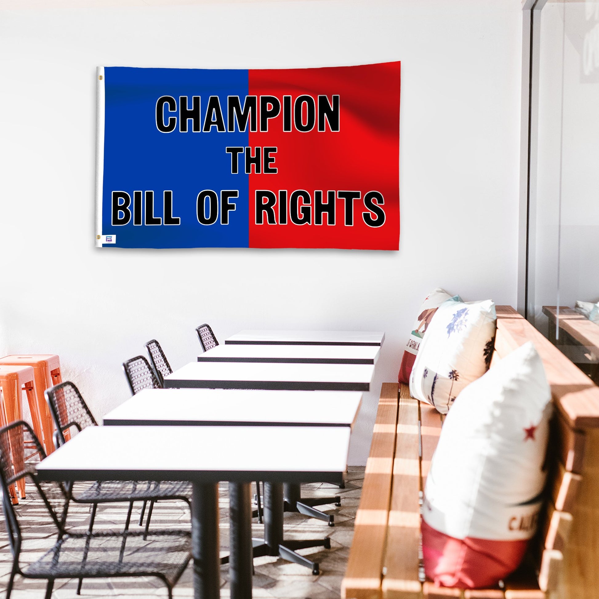 A political flag in royal blue and crimson red with a political statement on a wall in a cafe setting.