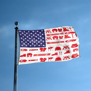 An american flag with the red stripes changed to match the theme "Snow Sports Stripes American" displayed on a high pole.