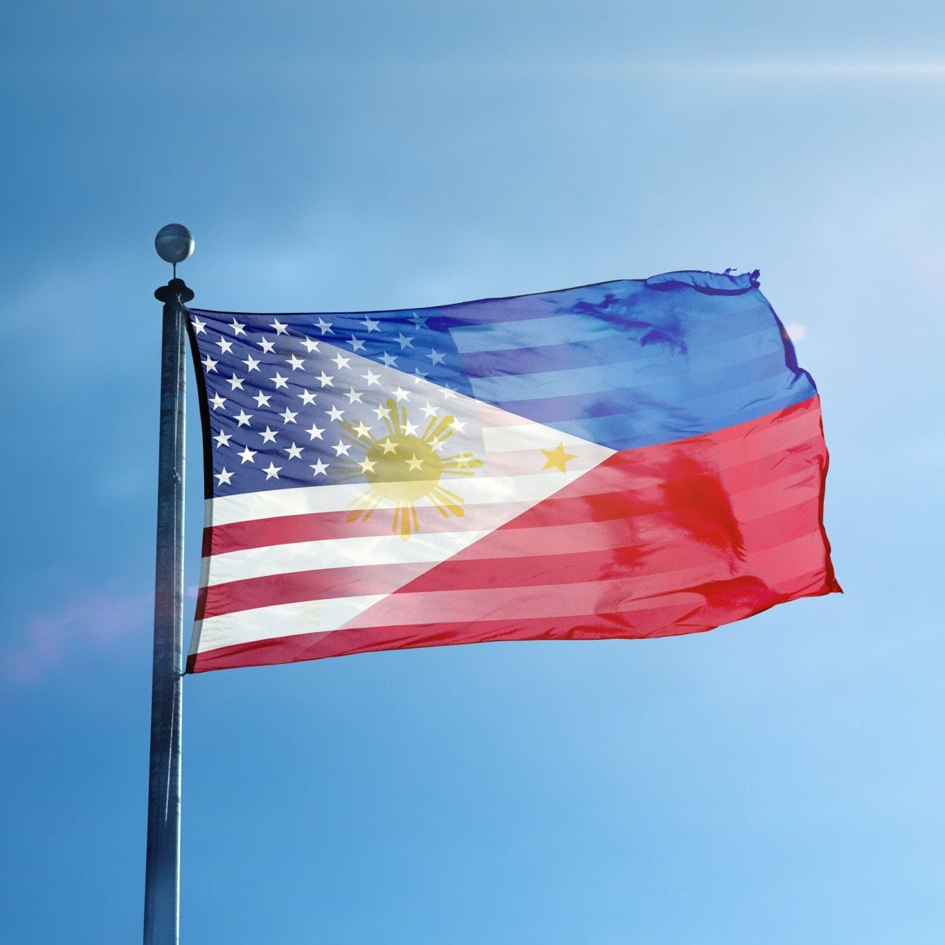 A hybrid flag on a flag pole featuring elements of the American and Filipino flags, with a predominantly red and blue color scheme and a sun motif.