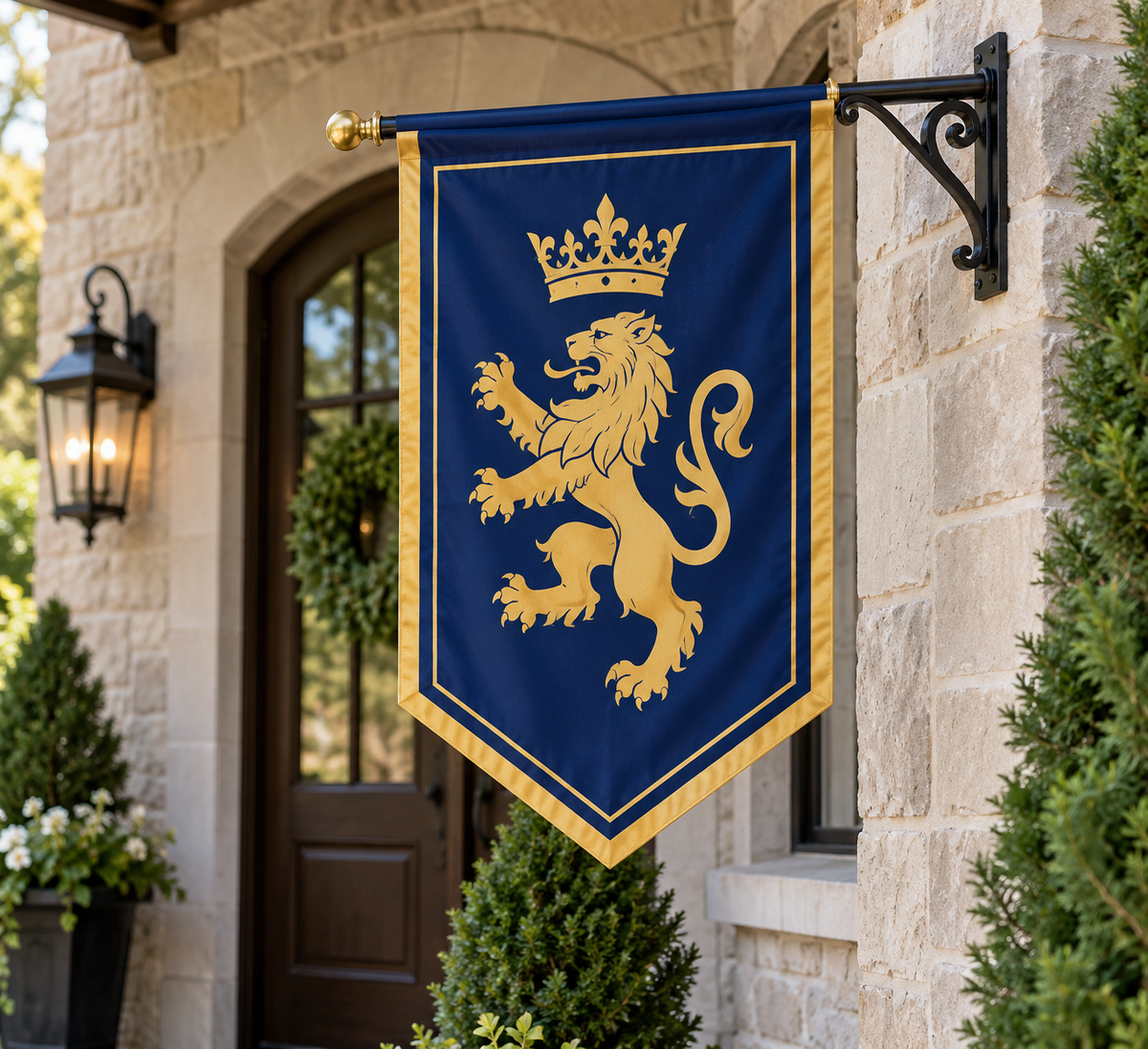 Bannerfi Custom Gonfalon Flag: blue, gold lion and crown, gold border, mounted on a wall bracket by a stone house.