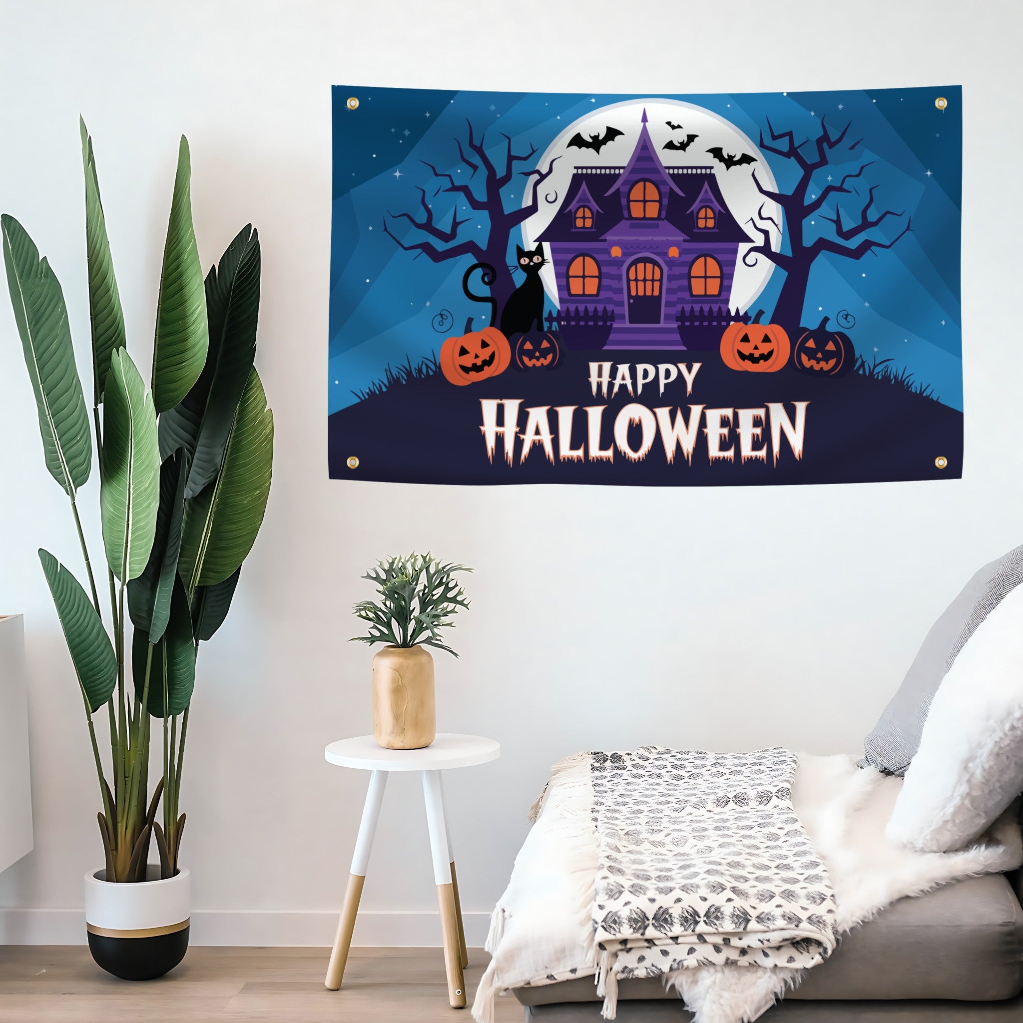 Halloween-themed decorative flag banner with a haunted house and pumpkins on a wall above a sofa.