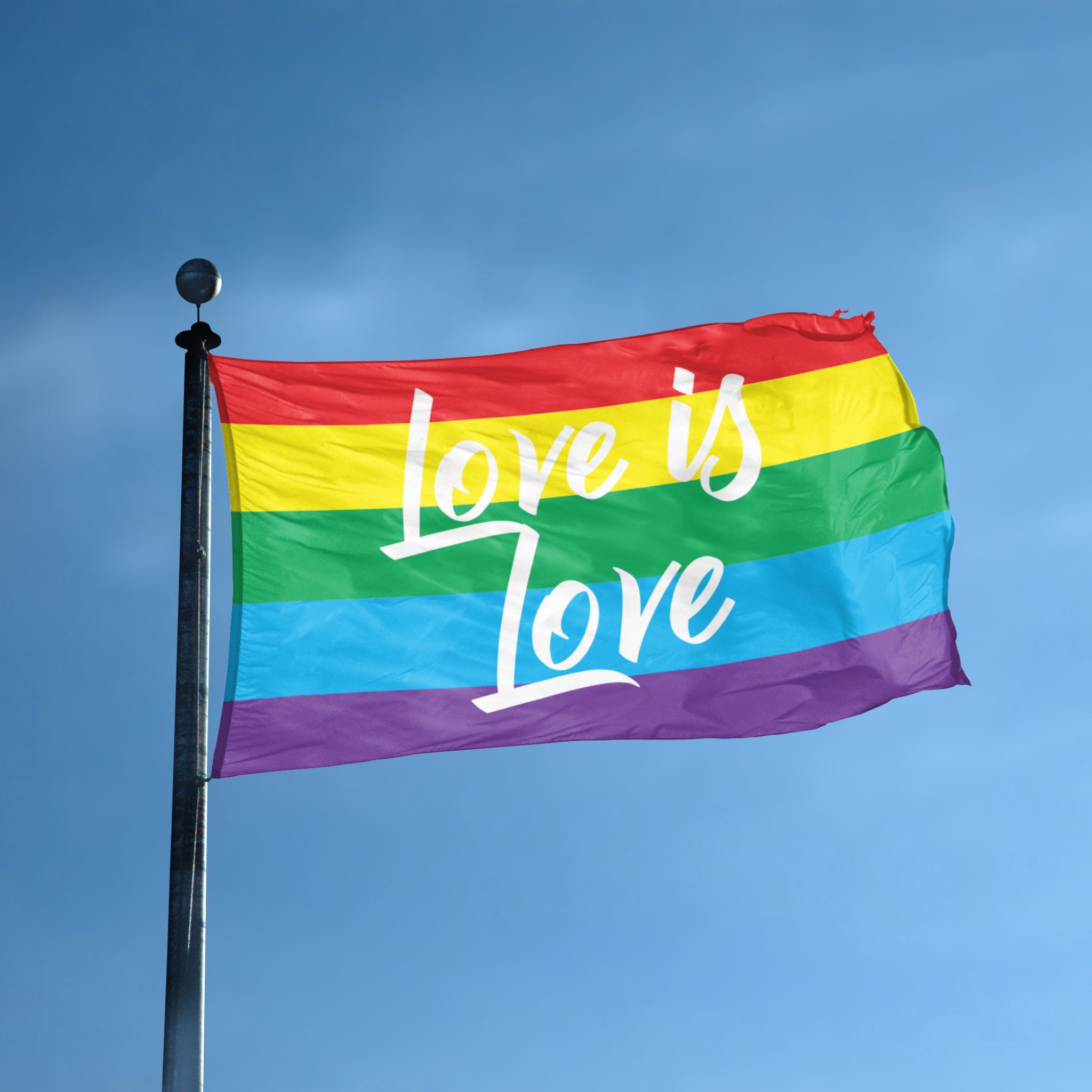 Rainbow flag with 'Love is Love' text against a clear blue sky