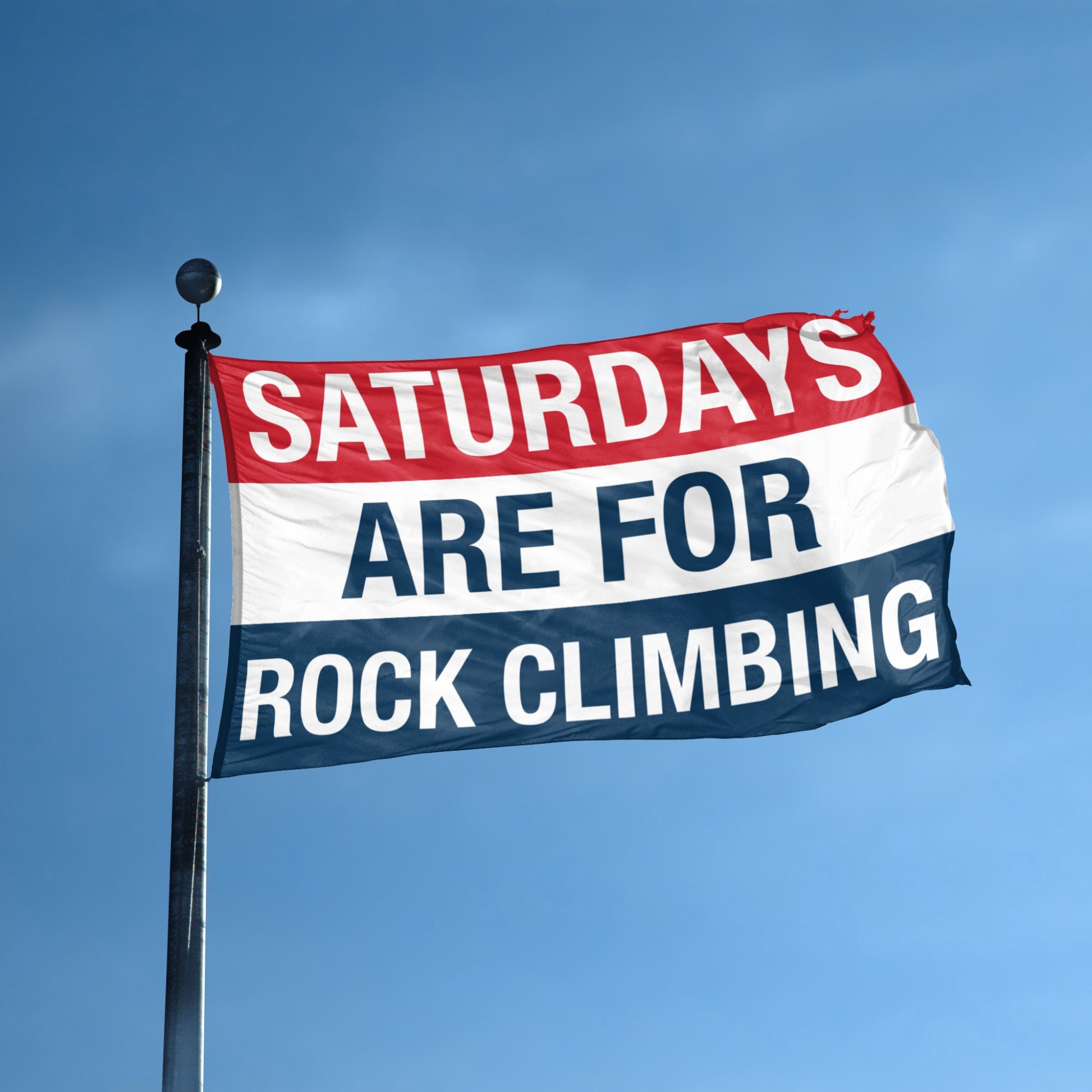 Flag with 'Saturdays are for rock climbing' text against a blue sky