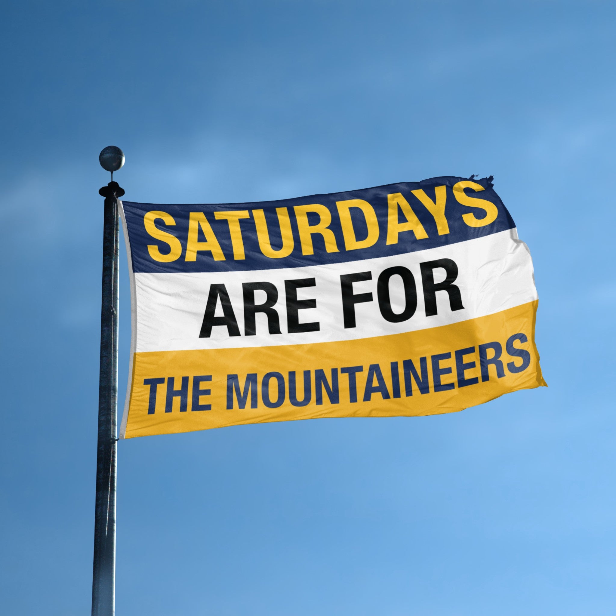 Flag with 'Saturdays are for the Mountaineers' text against a blue sky
