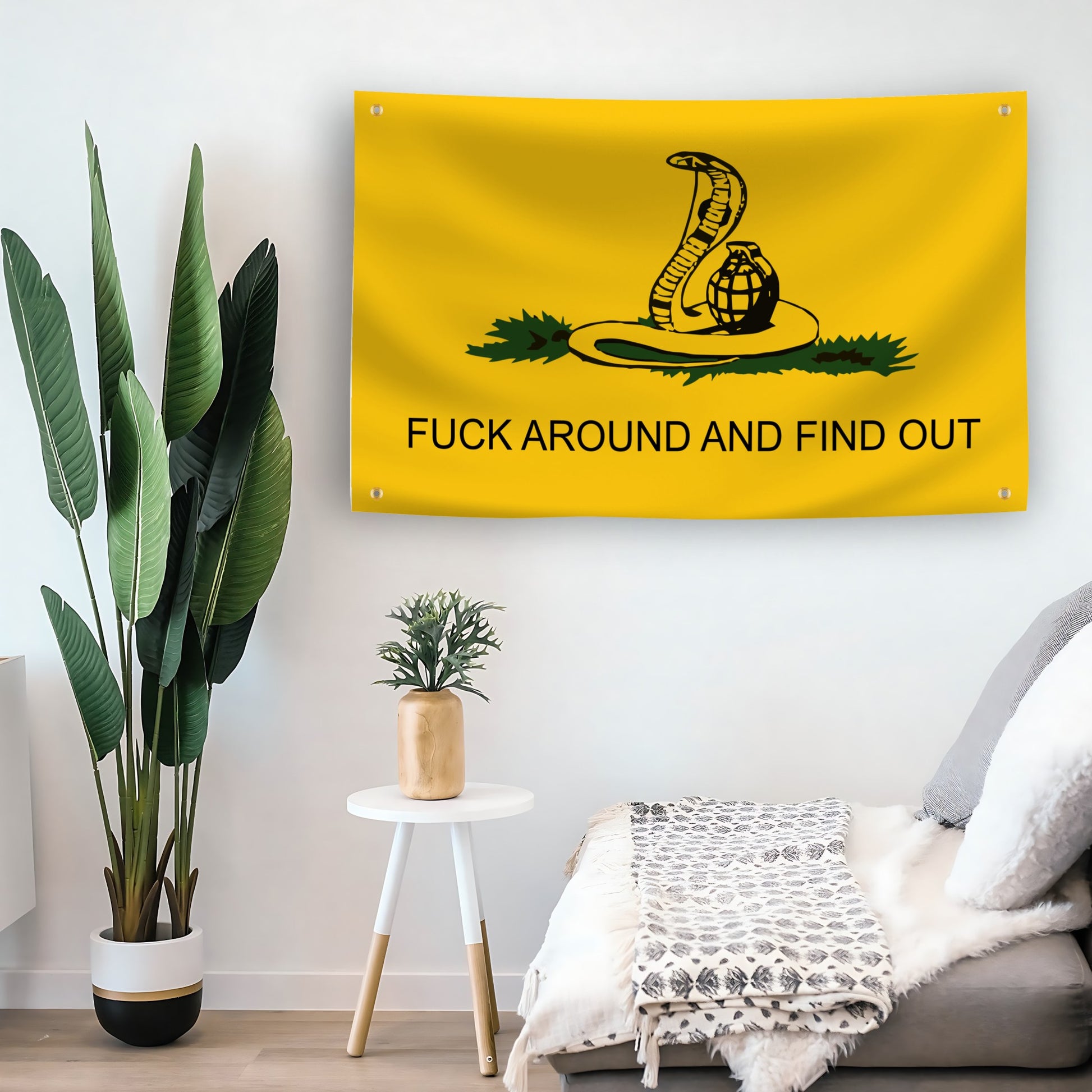 Yellow "fuck around and find out" flag with a snake and granade design hanging on a living room wall