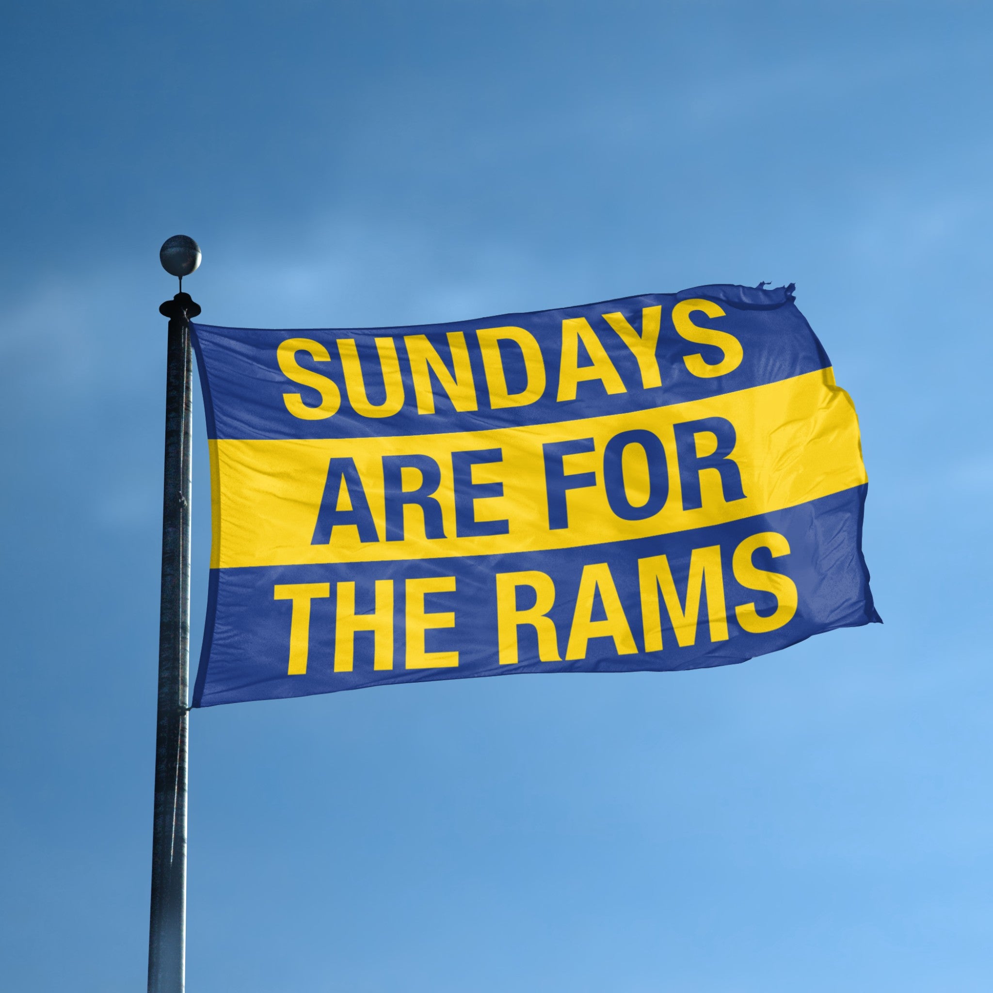 Flag with 'Sundays are for the Rams' text against a blue sky