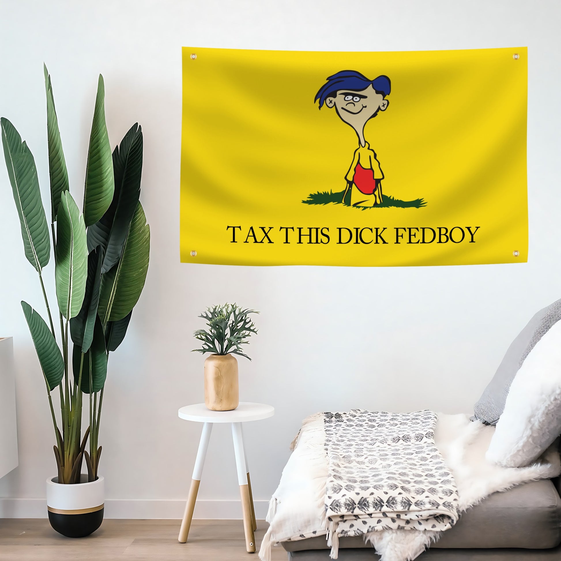 Yellow flag banner with "Tax This Dick Fedboy" hanging on a wall above a sofa.