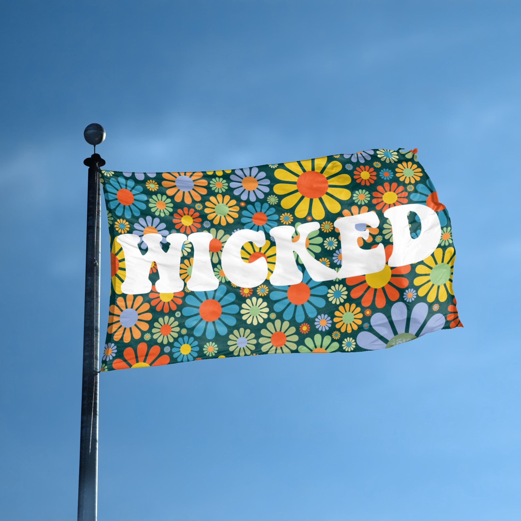 A flag with the theme "Wicked Floral" displayed on a tall flag pole and blue skies.