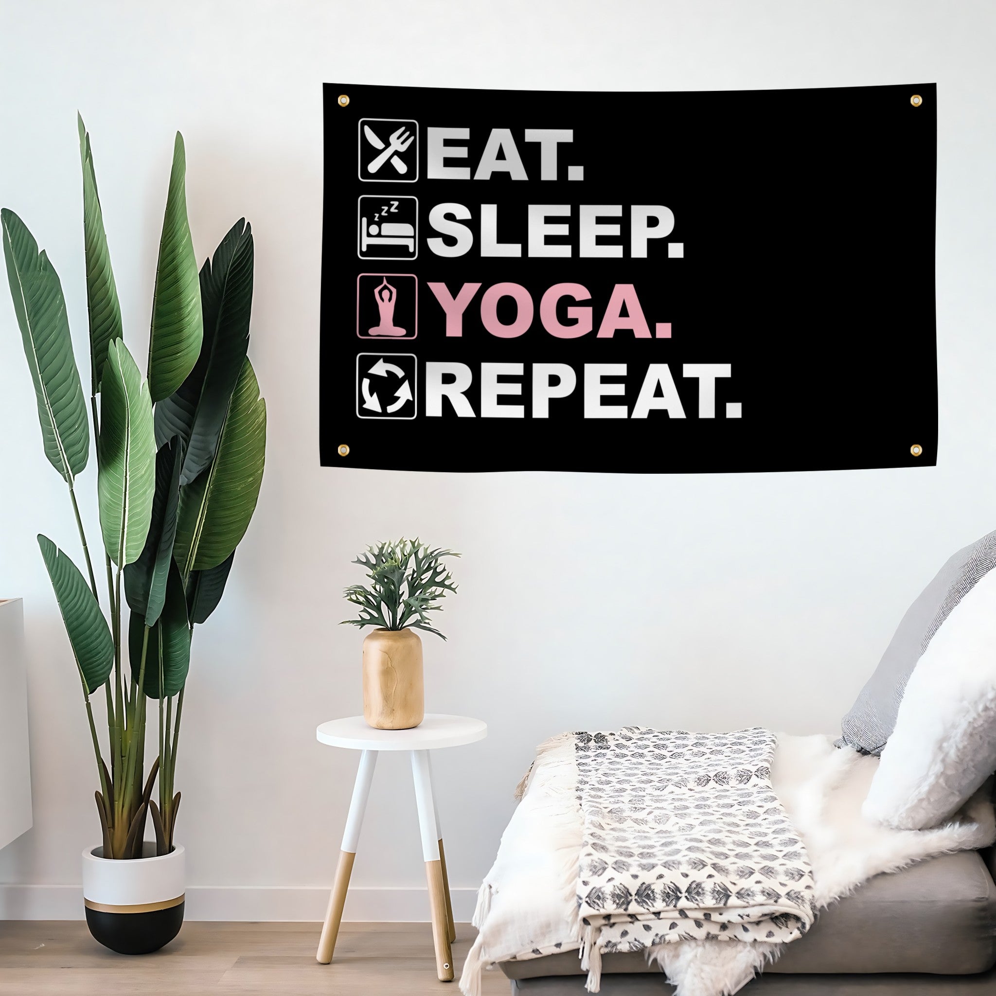 A flag banner with the text "Eat Sleep Yoga Repeat", with a black, white and pink color scheme mounted on a wall.