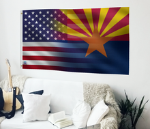 Load image into Gallery viewer, a living room with a white couch and a flag on the wall
