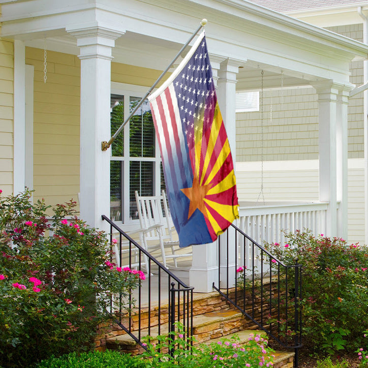An American and Arizona flag hybrid on a porch next to a house.