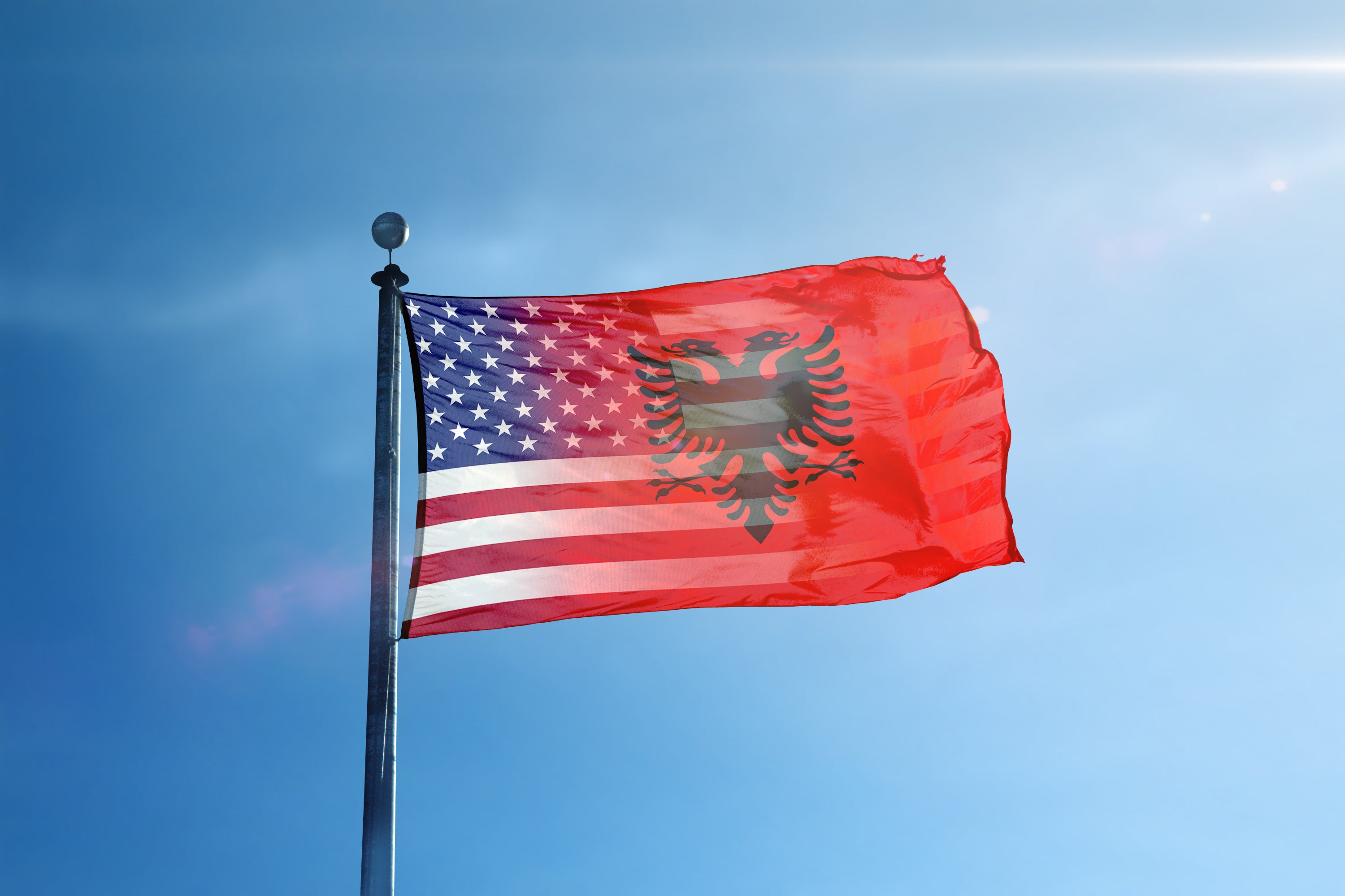 a flag flying in the wind on a sunny day